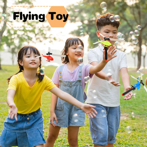 Children playing with Epic 12 Pack Handheld Flying Helicopters And Plastic Airplane Toys in a park.