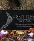 Granite Bird Portrait Memorial Stone Custom Engraved Marker For Parrots Canaries Finches Lovebirds, in garden setting with flowers.