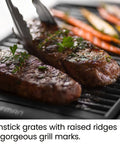 Steaks and vegetables cooking on Smokeless Indoor Grill With Nonstick Cooking Surface And Adjustable Temperature From Warm To Sear For Realistic At Home BBQ Flavor Easy Cleanup With Dishwasher Safe Water Tray Black