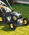 Lawn mower on grass with 10 Inch Solid Rubber Dolly Wheel Set With Flat Free 4.10 To 3.50-4 Tires, 5/8 Inch Bearings, 2.2 Inch Offset Hub.
