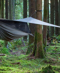 Cub Zip Kids Camping Hammock Hunter Green Side Entry With Full Length Zipper set up in forest with campfire nearby