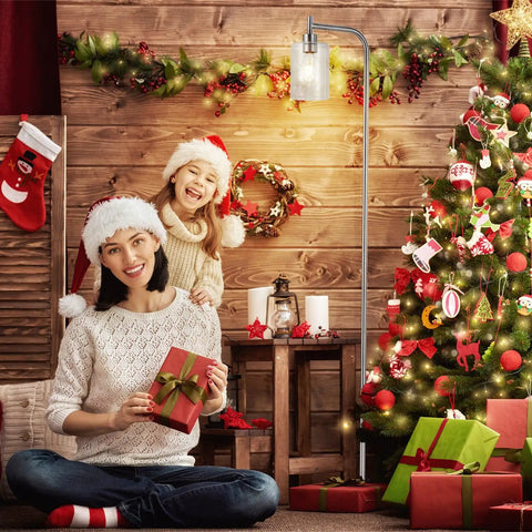 Festive room with Christmas tree, presents, family in Santa hats beside Frosted Glass Globe Floor Lamp With 9W LED, cozy warm lighting.