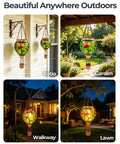 Glass Hot Air Balloon Solar Lantern With Flame Hand Painted Artwork Realistic Flickering Flame Hummingbird Accent Rustproof Metal Outdoor Solar Light For Garden Or Yard Easy Setup And Eco Friendly shown hanging in patio, garden, walkway, lawn at night.