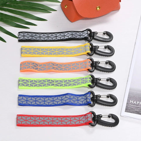 Double Sided Reflective Safety Keychain 4 Pack With Plastic Buckle, in various colors, laid flat on a table.