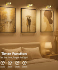 3 Pack Wireless Picture Lights For Wall, Battery Operated Poster Lamps With Polished Gold Finish illuminating framed artwork.
