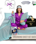 Woman sitting on bed with Grounding Sheet Set Queen Size With Twelve Percent Silver Fiber Four Percent Silk Eighty Four Percent Cotton Blend For More Restful Sleep Includes Fitted Sheet Flat Sheet Two Pillowcases Silver Eye Mask Travel Bag And Grounding Cables.