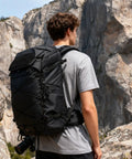 Person wearing 35L Camera Backpack For Photographers And Videographers, Built Tough Rugged Outdoor Gear Bag For DSLR in mountain setting