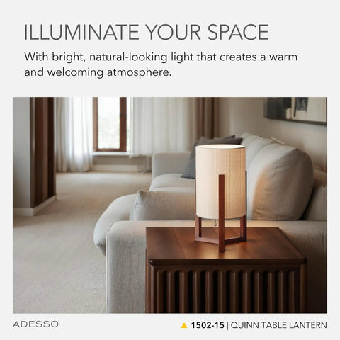 Quinn Table Lantern With Walnut Birch Wood Crisscross Base And Natural Linen Shade on a wooden table in a cozy living room.