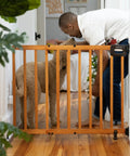 Man interacting with dog through Stairway Baby Gate For Stairs And Doorways Fits 30 To 48 Inch Openings 32 Inch Tall Oak Wood Safety Gate
