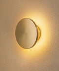 DANCYHOME 6.7" Rechargeable LED Wall Sconce in Brushed Brass mounted on a textured wall, softly illuminating space.