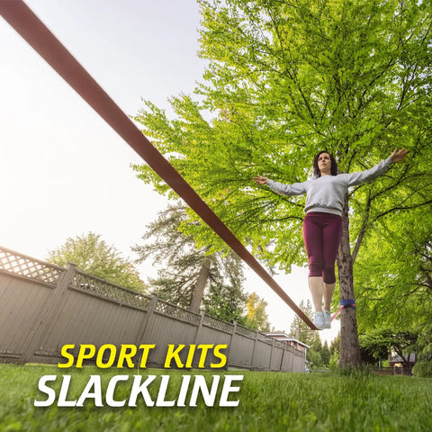 Person balancing on a Slackline Kit With Training Line Tree Protectors Ratchet Protectors Arm Trainer in a backyard setting.