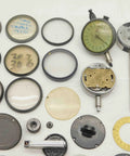 Solid Haul Of Dial Test Indicator Spare Parts And Heavy Duty Hardware For Precision Measuring Tools BR11576CZ5 assorted metal and glass components laid out for precision measurement