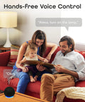 Family using hands-free voice control with smart speaker on table, reading together on red couch, natural home setting.