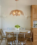 Handcrafted Rattan Chandelier With Three Bright Bulbs For Your Dining Room Or Kitchen Island, suspended over a round white table.