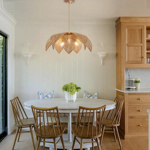 Handcrafted Rattan Chandelier With Three Bright Bulbs For Your Dining Room Or Kitchen Island, suspended over a round white table.