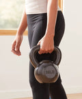 Person holding a 35LB Rock Solid Cast Iron Kettlebell With Wide Comfort Grip for strength training and daily lifts.