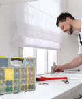 Man using sink with Set Of Four Plastic Clear Top Tool And Parts Organizer Box Set for Grab And Go Garage visible on counter