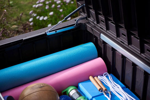 Open Beefy Westwood 150 Gallon Resin Outdoor Storage Box with exercise mats and gear inside, showing spacious storage capacity