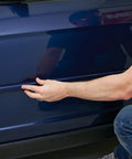 Applying Super Strength Automotive Tape 03609 - 1/2 in x 5 ft single roll to car side trim for secure bonding