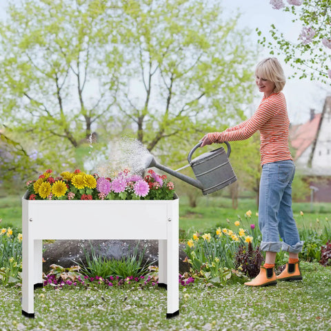 Woman watering flowers in a Raised Garden Bed With Detachable Legs, Elevated Metal Planter Box For Vegetables, Herbs And Flowers, Ideal For Outdoor Backyards, Patios, Decks Or Balconies, Spacious 23.6 In L By 10.6 In W By 17.7 In H