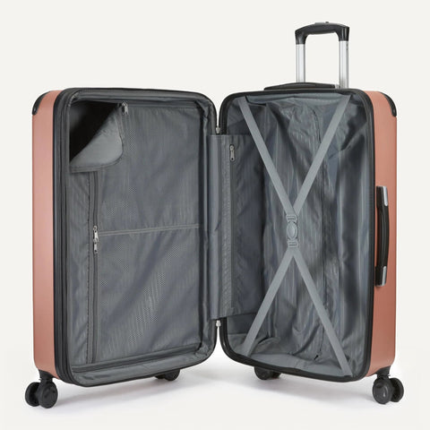 Open Amazon Basics 22-inch expandable hardside luggage in rose gold with gray interior, mesh pocket and cross straps.