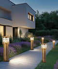 Weatherproof Aluminum Post Cap Lights For Deck And Yard With Bright Acrylic Diffuser illuminating a garden pathway at dusk.