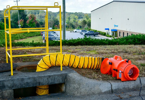 Beefy Industrial Com-Pax-Ial Blower Kit With Canister And 8 Inch By 25 Foot Duct in use, orange polyethylene housing on ground