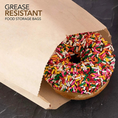 A sprinkled donut inside a brown paper sandwich bag from a 200 pack with 8 by 6 by 1 gusset sized for bakery treats, compostable.
