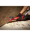 M18 FUEL Oscillating Multi Tool Kit With Brushless Power And Beast Mode Speed in use cutting through wood on a construction site.