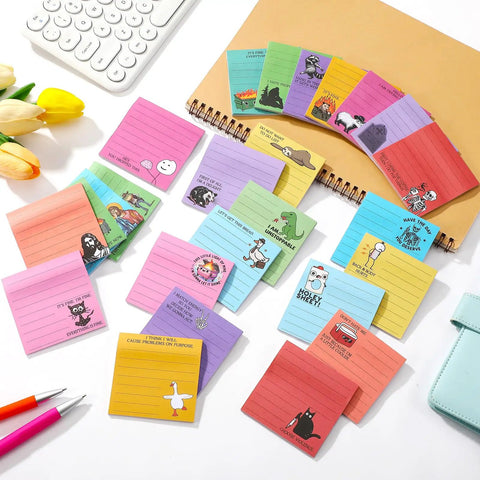 100 Pack Funny Sticky Notes for Work 3 by 3 Inches Sarcastic Self Adhesive Notepads with 25 Designs laid out on desk