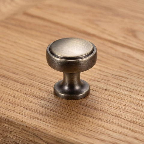 Close-up of a brushed zinc alloy cabinet pull on wood surface, part of 4 Pack Brushed Zinc Alloy Cabinet Pulls Single Hole Drawer Handles For Kitchen Cabinetry Bedroom Dresser Bathroom Vanity Wardrobe Hardware.