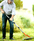 Person using All Purpose Lawn Thatch Rake With 15 Inch Head Beefy 19 Tines 68 Inch Adjustable Handle Heavy Duty Metal Dethatcher Dead Grass Remover Tool For Yards And Gardens Easy Manual Dethatching Rake For Thick Turf on grass