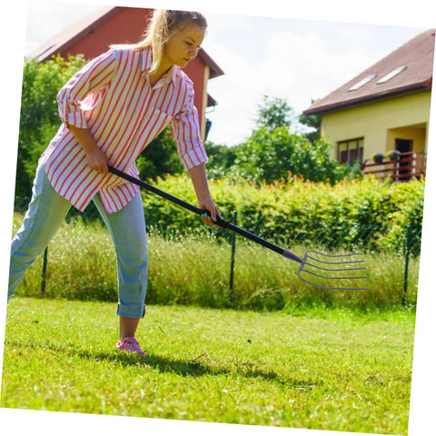 Person using Heavy Duty Handheld Manure Fork Workhorse For Farm Work And Yard Cleanup With Durable Prong Design And Rust Resistant Construction.