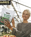 Person holding Fast Draining Succulent And Cactus Potting Soil Mix With Added Nutrients For Healthy Roots, 4 Quarts bag indoors.