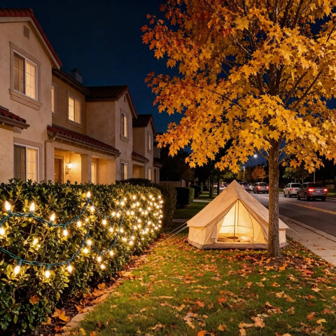 Night scene with 200 LED Warm White Christmas Lights on 66ft Green Wire UL Certified illuminating hedges beside a tent