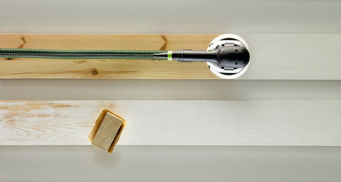 Multi-Jetstream Dust-Free Random Orbital Finish Sander on wood boards showcasing its dust-free capability and ergonomic design.