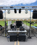 Outdoor stage setup with speakers and tables under a tent, suitable for using Endless 3ft Polyester Round Sling for rigging equipment.