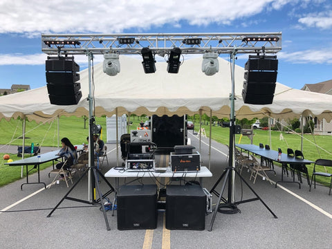 Outdoor stage setup with speakers and tables under a tent, suitable for using Endless 3ft Polyester Round Sling for rigging equipment.