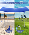 Family Friendly Beach Tent Canopy Sun Shade 10x10 Ft Portable Wind Resistant Shelter set up on sand and grass with poles and sandbags.