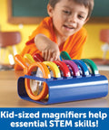 Child using Six Jumbo Science Magnifiers With Stand For Kids Ages 3 Plus, Kid Friendly Classroom Observation Tools with colored lenses.