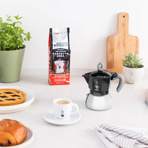 Induction Moka Pot That Just Works On Any Hob 4 Cup Espresso Maker 5.7 Oz Black Aluminum Upper With Stainless Steel Boiler on counter