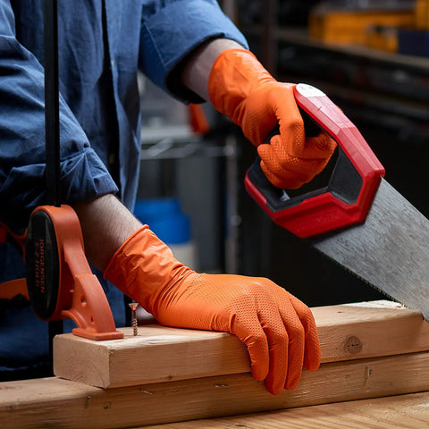Heavy Duty 100 Count Orange Nitrile Gloves With Thick 8 Mil Industrial Build Featuring Rock Solid Grip And X Large Fit For Demanding Automotive Jobs That Deliver Real World Safety And Badass Durability in use while sawing wood.