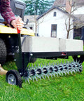 Man using Tow Behind Spike Aerator With Transport Wheels, 40-Inch Lawn Aerator on green grass, showing 11 tine stars and spikes