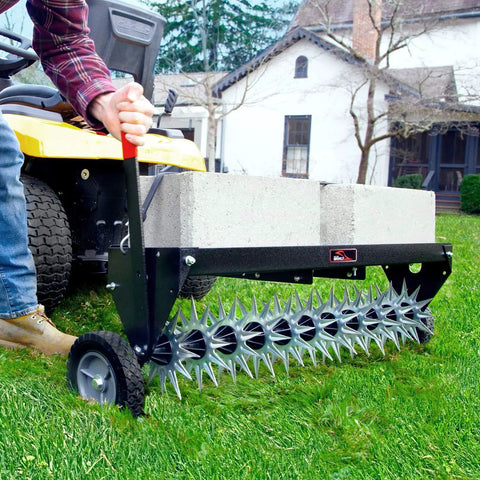 Man using Tow Behind Spike Aerator With Transport Wheels, 40-Inch Lawn Aerator on green grass, showing 11 tine stars and spikes