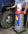 Mechanic using Lincoln 917 Pro Grade 50 To 1 Pneumatic Grease Pump, Heavy Duty Air Operated For 120 Lb Drums on vehicle wheel.