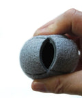 Hand holding a grey felt Heavy Duty Precut Tennis Ball Floor Protector Glide for Classroom Furniture, open end visible.