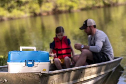 Ready Set Fish 3 Tray Tackle Box With Starter Tackle Kit on boat with aqua blue lid, tan base, beside angler