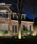 Low Voltage Landscape Lighting Kit 8 Pack With Replaceable 3W LED Bulbs illuminating a tree and brick house at night