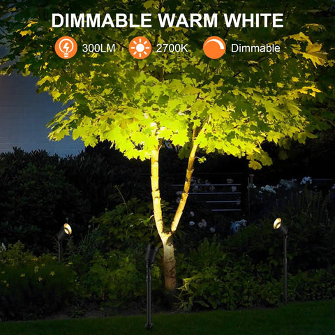 Lit Smart Outdoor Spotlight Kit 4 Pack 12V Low Voltage Landscape Lights illuminating a tree at night with warm white light.