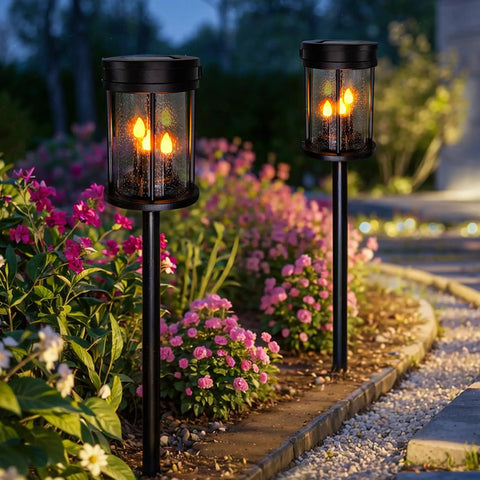 Outdoor Solar Stake Lights With Flickering Candle Lanterns For Yard And Patio 2 Pack Black Garden Pathway Lights next to flowers
